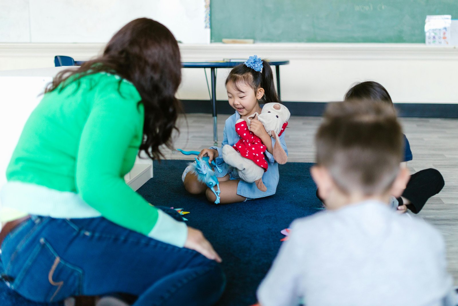 Happy children playing with teacher